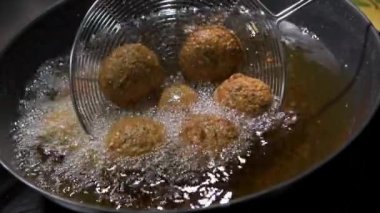 Ramazan Zevkleri, Humus Falafel, Orta Doğu Kültürü. Falafel topları kızartılıyor, Ateş Pişiriliyor, Kızarmış sokak yemekleri, yüksek kaliteli 4K görüntüler