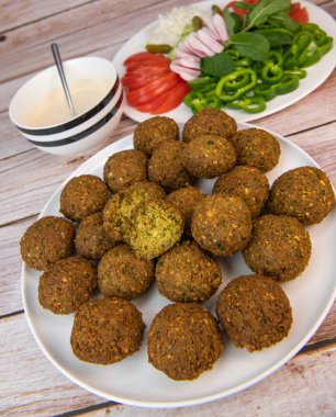 Kızarmış falafel köftesi ve tahini sosu, yanında da doğranmış baklagiller ve nohut. Yüksek kalite fotoğraf