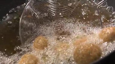 Ramazan Zevkleri, Humus Falafel, Orta Doğu Kültürü. Falafel topları kızartılıyor, Ateş Pişiriliyor, Kızarmış sokak yemekleri, yüksek kaliteli 4K görüntüler