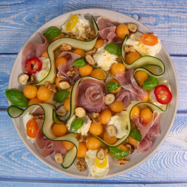 MELON, MOZARELLA, BASIL and CURED Ham Salatası, CUCUMBER SLICE, ORANGE VINAIGRETTE. Yüksek kalite fotoğraf