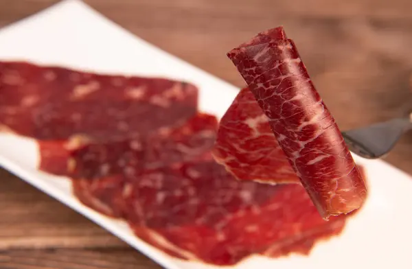 Dry-cured Spanish ham, Serrano ham, Bellota ham, Italian prosciutto crudo or Parma ham, wagyu slice. High quality photo