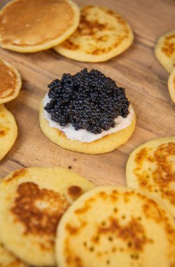 Siyah havyar ve krem peynirli jaluziler, şenlikli bir tabakta, mini gözlemeler, zarif bir aperatif, kaliteli bir fotoğraf.