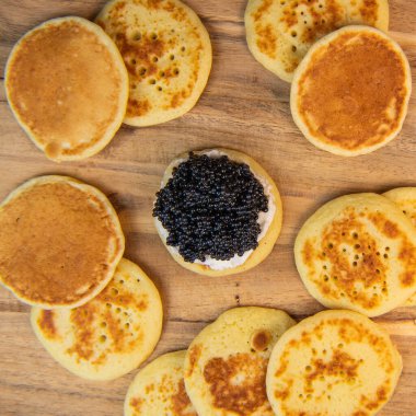 Siyah havyar ve krem peynirli jaluziler, şenlikli bir tabakta, mini gözlemeler, zarif bir aperatif, kaliteli bir fotoğraf.