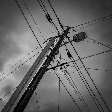 Çok sayıda elektrik ve telefon kablosunun kesişiminin siyah ve beyaz görüntüsü, yüksek kaliteli fotoğraf