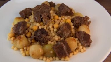 Moughrabieh, Lübnan mutfağında çok sevilen bir yemektir: Beef ve küçük soğanlı, SEMOLINA PEARLS ve CHICKPEAS. Yüksek kaliteli video