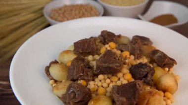 Moughrabieh, Lübnan mutfağında çok sevilen bir yemektir: Beef ve küçük soğanlı, SEMOLINA PEARLS ve CHICKPEAS. Yüksek kaliteli video