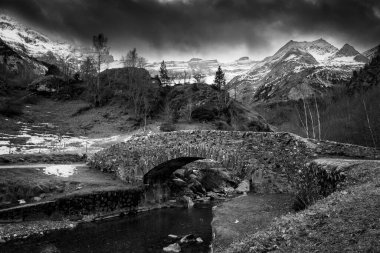 Sunset over the Pyrenees mountains, Circus of Gavarnie and the old stone bridge spanning the stream, High quality photo clipart