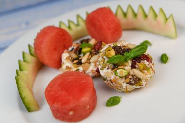 Kurutulmuş meyve, tabak, fındık ve pastırma ile kaplanmış Feta Yüzüklerinin Salatası.