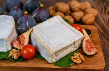 Selection of French cheeses from Normandy, AOP, Livarot, Neufchatel, Pont leveque, Rye bread, figs, walnuts, grapes, elderberry gelee. High quality photo clipart