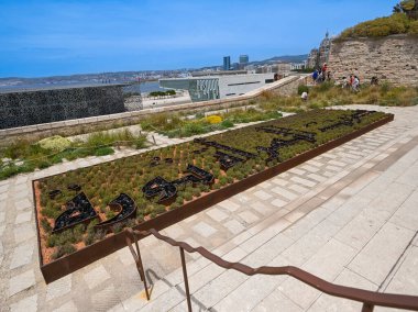 MARSEILLE, FRANCE - June 07, 2024: Exterior view under the Memorial of the Deportations with arabic sign in garden, High quality photo clipart