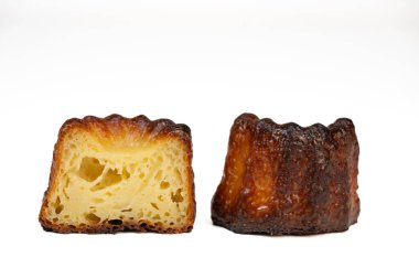 Caneles de Bordeaux, beyaz masa arkaplanlı geleneksel Fransız tatlısı, yüksek kaliteli fotoğraf.