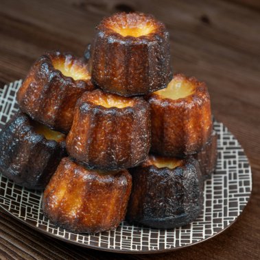 Caneles de bordeaux, traditional French sweet dessert with white table background, High quality photo clipart