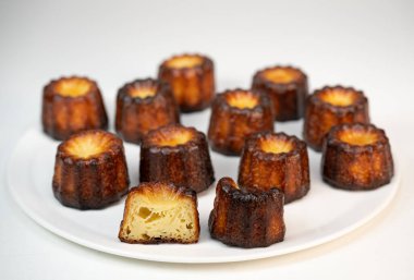 Caneles de bordeaux, traditional French sweet dessert with white table background, High quality photo clipart