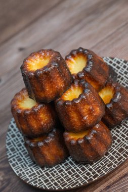 Caneles de Bordeaux, beyaz masa arkaplanlı geleneksel Fransız tatlısı, yüksek kaliteli fotoğraf.