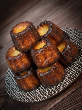 Caneles de Bordeaux, beyaz masa arkaplanlı geleneksel Fransız tatlısı, yüksek kaliteli fotoğraf.