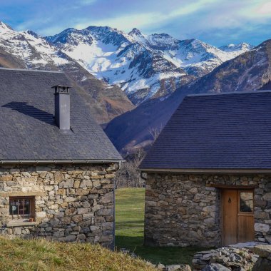 Karla kaplı görkemli dağlarla çevrili sakin bir vadide iki kır evi yan yana duruyor. Manzara doğada barışçıl bir geri çekilme sunuyor..