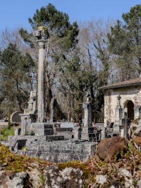 Eglise Saint Pierre 'deki La Croix du Cimetiere' de sakin bir öğleden sonra, Mons, Gironde, Fransa 'da eski mezarlıklar ve yemyeşil yeşilliklerle çevrili, bir huzur hissini yansıtıyor..