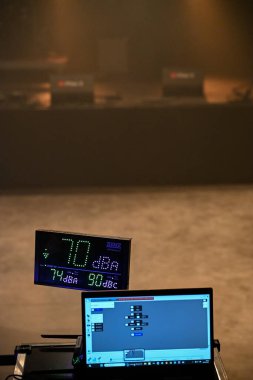 Ses seviyesi, 70 DBA 'yı dijital ekranda gösteren bir konserde izleniyor. Ses yönetiminin bir parçası olarak desibel seviyelerini izlemek için bir dizüstü bilgisayar çalıştırır.