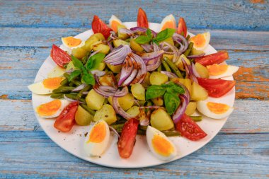 Taze salata, yeşil fasulye, küçük patates, yumurta, domates, fesleğen, kırmızı soğan ve balzamik sirke sosu. Yüksek kalite fotoğraf
