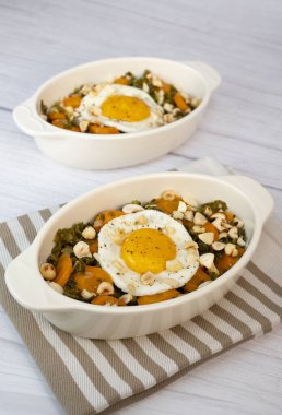 Lahana, havuç ve sarımsaklı poellee, doğranmış fındık, kaju ve badem ve kızarmış yumurta için kızarmış sarımsaklı ekmek ve zeytinyağı.