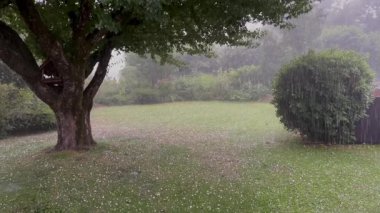 Haziranda dolu fırtınası, yıldırımlar ve dolu fırtınalarıyla dolu yağması, yoğun buz kristalleri kalkanı ile kaplı zemini terk etmesi, yüksek kalite 4K görüntü.