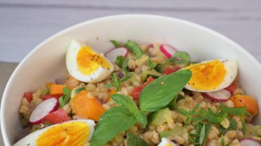 Haşlanmış yumurta ve limon suyu ve zeytinyağıyla giyinmiş taze yapılmış salata özellikleri kızarmış kabak, havuç, soğan, kırmızı biber ve fesleğen..