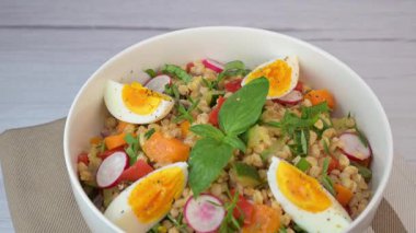 Haşlanmış yumurta ve limon suyu ve zeytinyağıyla giyinmiş taze yapılmış salata özellikleri kızarmış kabak, havuç, soğan, kırmızı biber ve fesleğen..