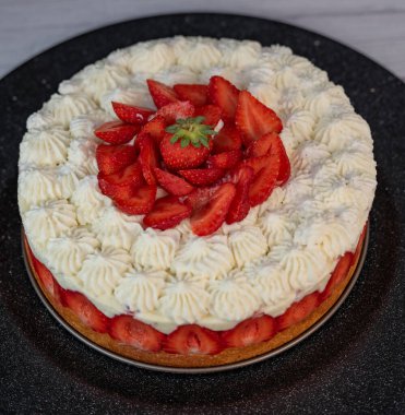 Bu daha Fraisier kek tabakaları taze çilek katmanları ve şantilya krem altın sünger tabanında, tatlı meraklıları için güzel sunulan özel bir toplantı sırasında.
