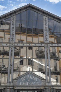 Cauterets Halles Pazarı, etrafındaki tarihi binaları yansıtan cam cepheleriyle modern ve geleneksel mimarinin karışımını gözler önüne seriyor..