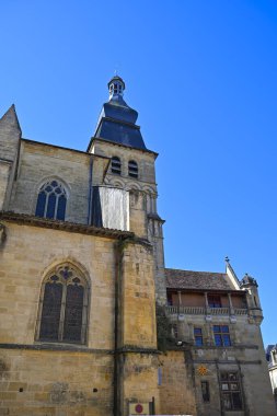 Dordogne 'daki Sarlat' ın büyüleyici caddeleri üzerindeki Katedral Saint-Sacerdos kuleleri, parlak mavi gökyüzünün arka planına karşı karmaşık taş çalışmalarını ve tarihsel önemini sergiliyor..