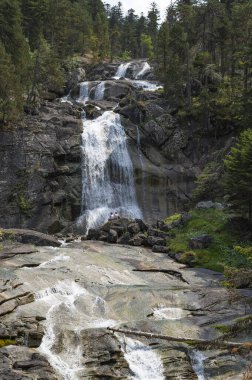 Ziyaretçiler, güneşli bir günde Pireneler bölgesindeki doğal güzellik ve sükunetin tadını çıkarmak için Pont dEspagne şelalesinin yanında toplandılar..