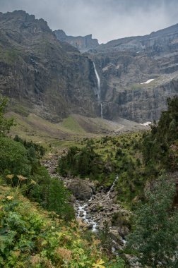Ziyaretçiler, yüksek uçurumlar, yemyeşil yemyeşil ve berrak bir gökyüzü altında muhteşem şelalelerin yer aldığı Cauteret Pireneleri 'ndeki Gavarnie Sirki' nin çarpıcı manzarasının keyfini çıkarıyorlar..