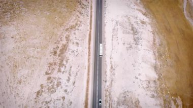 Çölde otobanda otobüs sürerken drone görüntüleri.