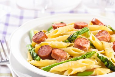 Fırında makarna, kuşkonmaz ve sosis.