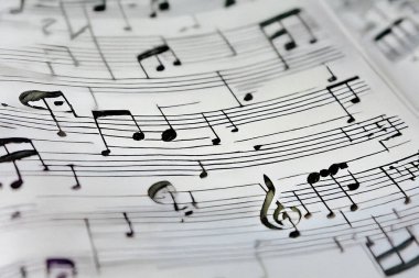 Müzikal kadrosundaki üçlü anahtar sembolü, müzik, melodi ve müzik notalarını temsil ediyor.