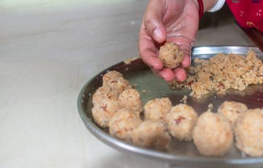 Ev yapımı hindistan cevizli laddu yapan bir kadının düşük açılı görüntüsü. Kapat ve seçici odaklan.