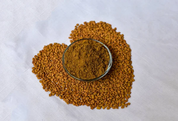 フェヌギリシャの種子 メティ は白い背景にハート形をしています シャンバラやヘルバの種子は 伝統的なインドの調味料アーユルヴェーダ食品です 料理や医療に用いられる — ストック写真