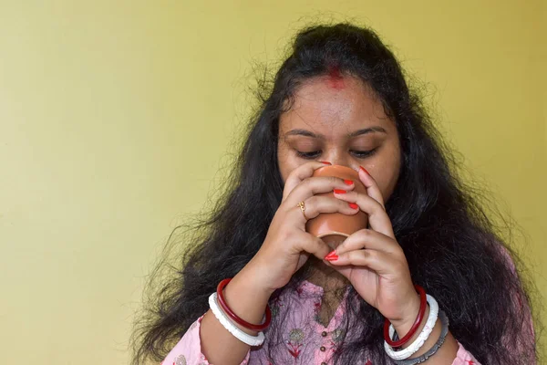 若いインド人女性がコーヒーや紅茶を飲んでいる 黄色の背景 カップに焦点を当てる — ストック写真