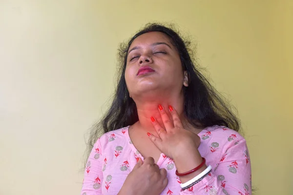 Throat pain concept. Young Indian woman touching painful neck. Sore throat in flu season. Selective focus