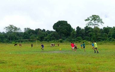 Jalpaiguri, Batı Bengal, Hindistan; 20 Ekim 2021: Kırsal kesimde futbol oynayan bir grup çocuğun aksiyon fotoğrafı.