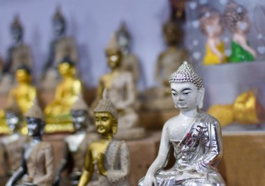 Satılık bir sokak dükkanında birçok heykel Buddha resmi.