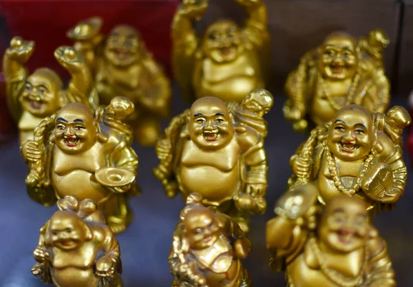 a group of golden laughing buddha statues isolated in a clean background. It is believed that keeping the statue of Laughing Buddha brings success and prosperity in the home. Selective focus.