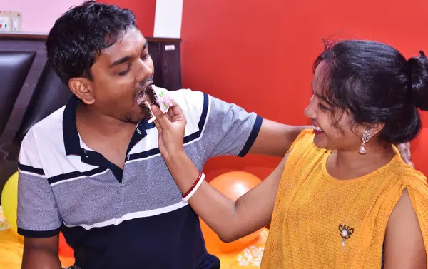 Indian couple celebrating birthday eating cake at home background Concept. Happy couple Lifestyle, holiday concept.