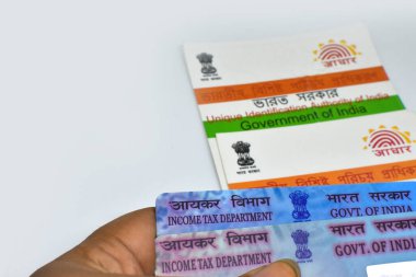 Batı Bengal, Hindistan, 21 Haziran 2024: Beyaz arka planda PAN ve Aadhaar kartları tutan Hintli bir adam seçici odaklı veya sığ alan derinliği