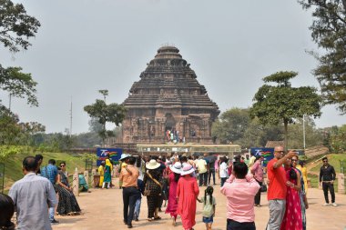 Konark, Orissa, Hindistan - 10 Mart 2023: İnsanlar 13. yüzyılda Kalinga hanedanı altında inşa edilen ve Güneş Tanrısı 'nın devasa bir savaş arabası olarak tasarlanan UNESCO' nun dünya mirası olan Güneş Tapınağı 'nı ziyaret ederler..