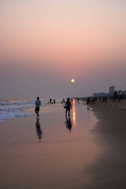 Puri, Hindistan, Kasım 04, 2024: Günbatımında Golden Beach 'te eğlenen turistler.