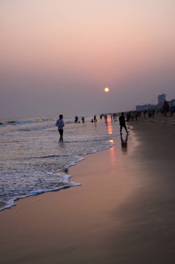 Puri, Hindistan, Kasım 04, 2024: Günbatımında Golden Beach 'te eğlenen turistler.
