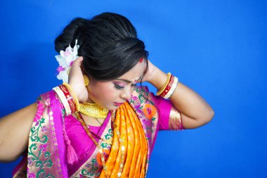 Hint gelini sari içinde, altın mücevherler takıyor ve saçına yasemin çiçeği çelenkleri takıyor..