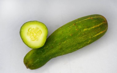 Beyaz arka planda taze salatalık ve salatalık boylamasına ayrılmış. Salatalık turşu ya da dilimleme için kullanılır..