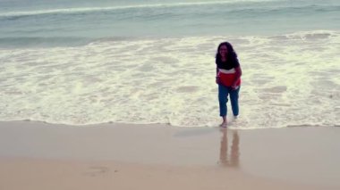 Hintli kadın kumsalda eğleniyor. Genç bir kadın sahilde yürüyor ve gülümsüyor. Manken Hindistan 'da sahilde poz veriyor. Puri Deniz Sahili 'nde tatilde olan bir kadın..